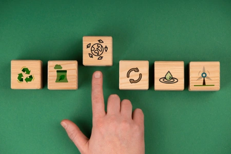 Icône d'économie circulaire sur des blocs en bois arborant des symboles de recyclage et de durabilité, représentant une gestion responsable des emballages.